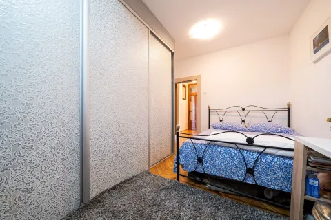 Bright bedroom featuring a large built-in wardrobe and a double bed. - image 29