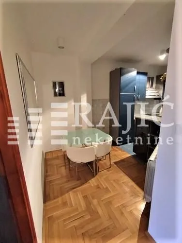 Dining area with a table and chairs and a view of the kitchen.
