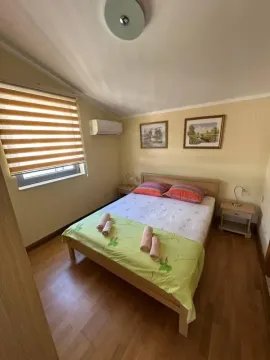 Spavaća soba sa bračnim krevetom, noćnim stočićima i prozorom sa roletnama. - image 5
