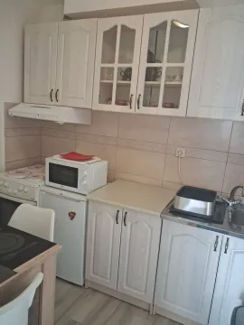Small kitchen with white cabinets, stove, refrigerator, and sink. - image 4
