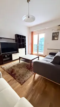 Dnevna soba sa garniturom, televizorom i izlazom na terasu. - image 2