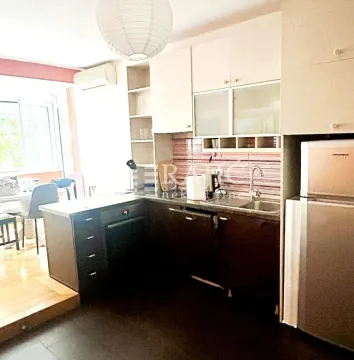 Small kitchen with dark cabinetry and built-in appliances. - image 7