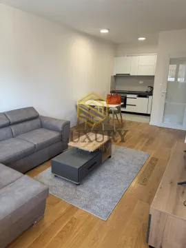 Living room with a sofa, coffee table and a dining area in the back. - image 11