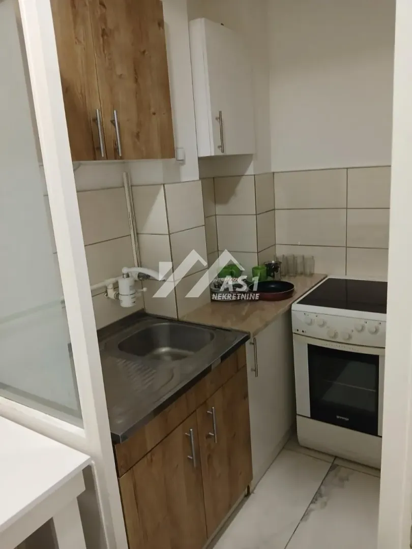 Smaller kitchen with a sink, cabinetry, and a stove.