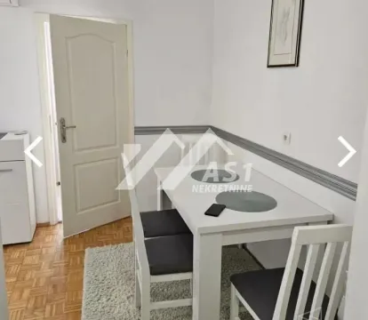Dining area with a white table and chairs next to white walls. - image 5