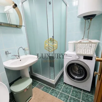 Small bathroom with washbasin, shower cabin, and washing machine. - image 8