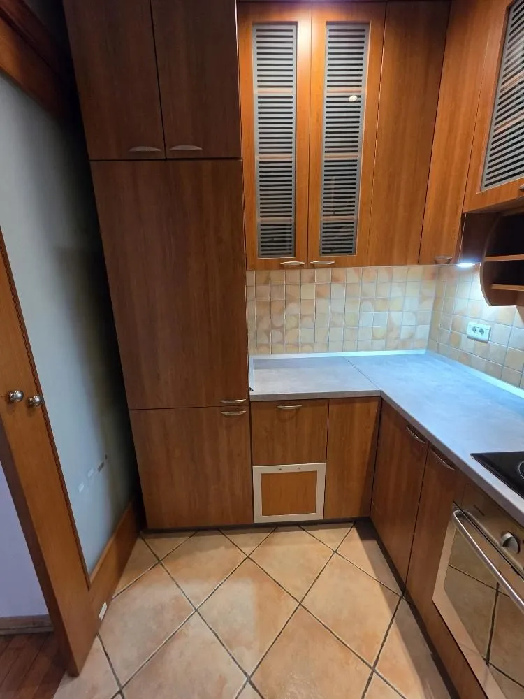 Kitchen with wooden cabinetry and ceramic tiles.