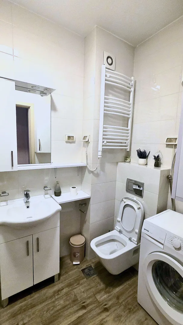 Bathroom equipped with a washbasin, toilet, washing machine, and a towel radiator.