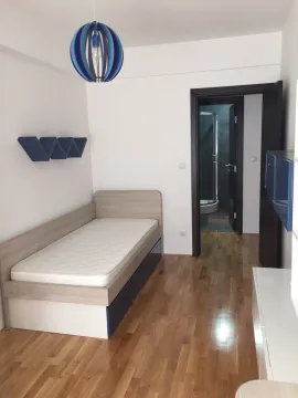 Bright bedroom with a single bed and a view looking into the bathroom. - image 5