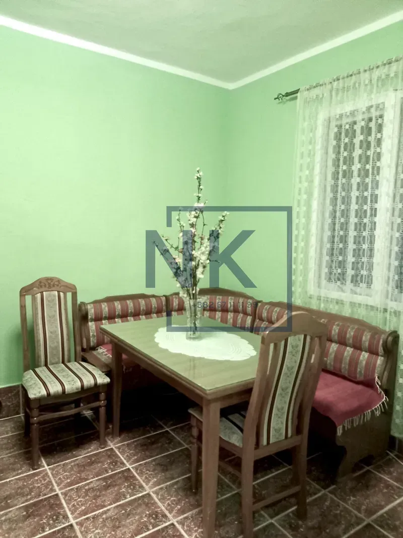 Dining area with a wooden table, corner bench and chairs.