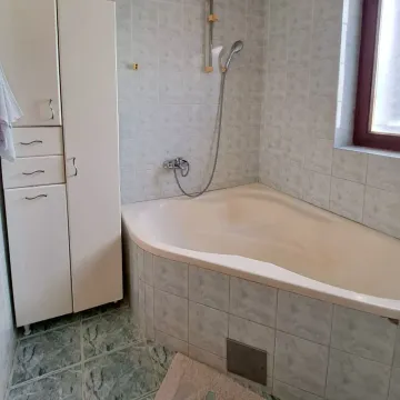 Kupatilo sa ugaonom kadom i bijelim ormarićem za odlaganje. - image 29