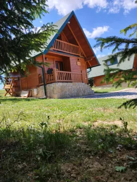 Pogled na drvenu vikendicu sa travnjakom i zelenilom u okruženju. - image 11