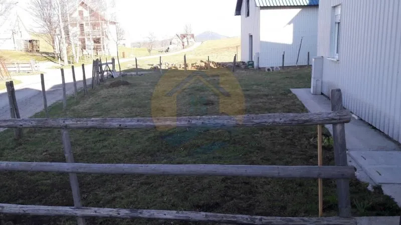 View of the fenced yard and surrounding houses in a rural setting.