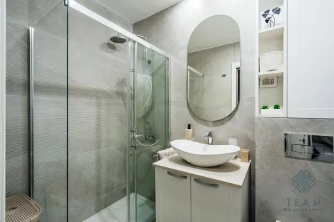 Modern bathroom with a shower cabin, washbasin, and a large mirror. - image 10
