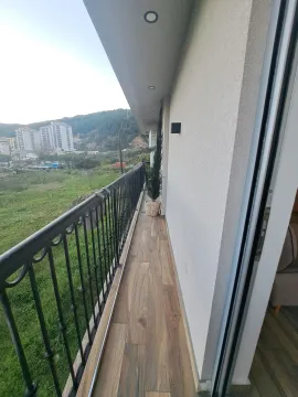 Dugi balkon sa drvenim podom i pogledom na prirodu i grad. - image 20