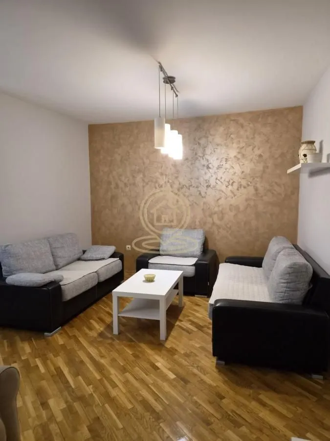 Dnevna soba sa garniturom za sedenje i stočićem.