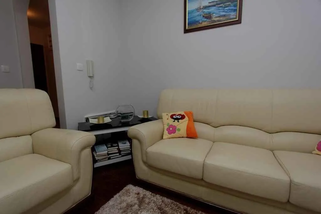 Living room featuring light leather sofas and a small side table.