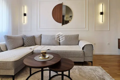 Living room with a sectional sofa, round coffee table, and decorative wall mirror. - image 5
