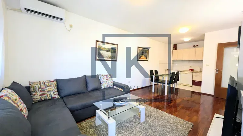 Living room with a corner sofa and a dining area in the background.