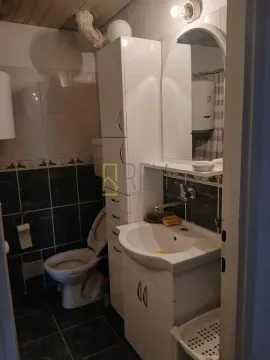 Small bathroom with a sink, cabinet, mirror, and toilet. - image 11