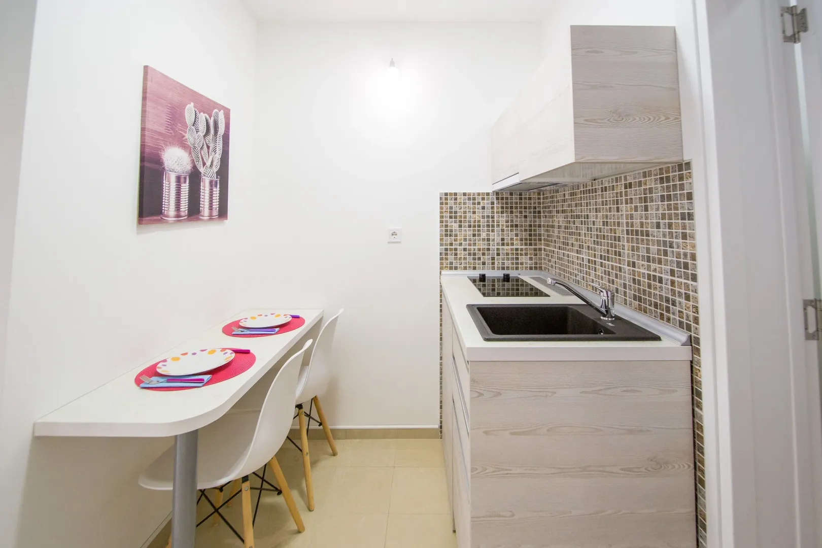 Small kitchen with a dining table and white cabinetry.