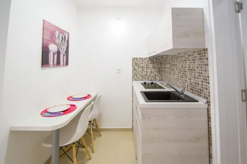 Small kitchen with a dining table and white cabinetry. - image 5