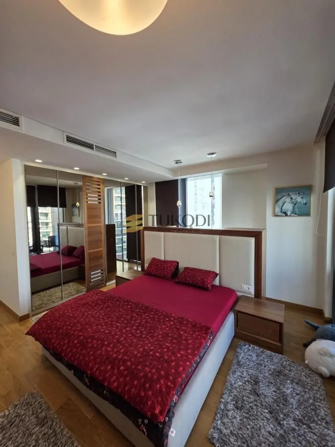 Spacious bedroom with a double bed and a mirrored built-in wardrobe.