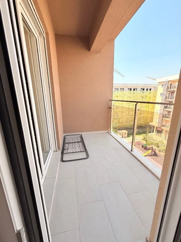 Prazan prostrani balkon sa pogledom na naselje.