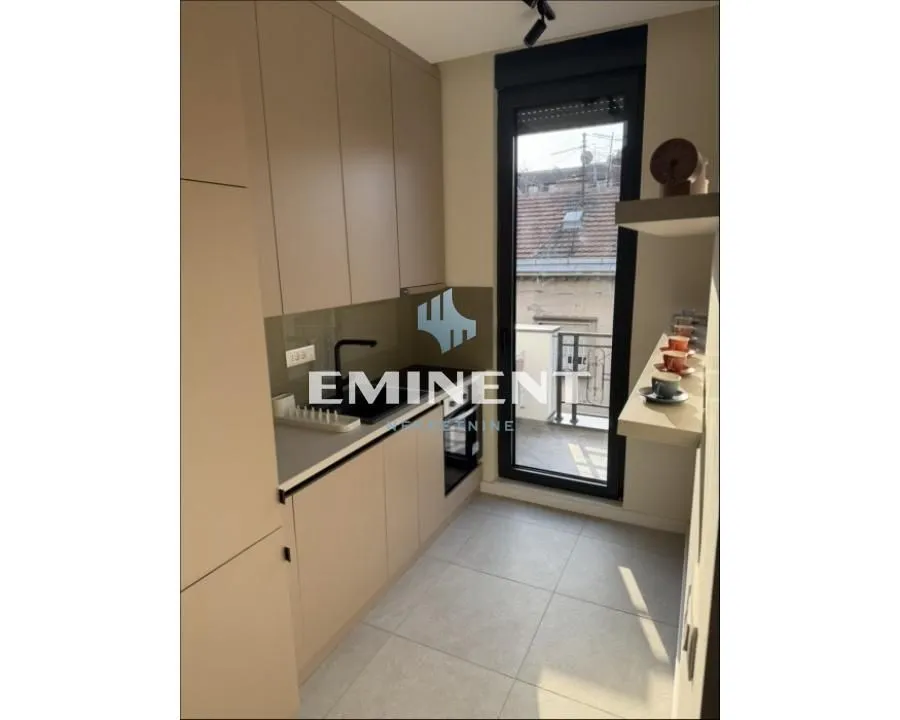Small modern kitchen with built-in units and access to the terrace.