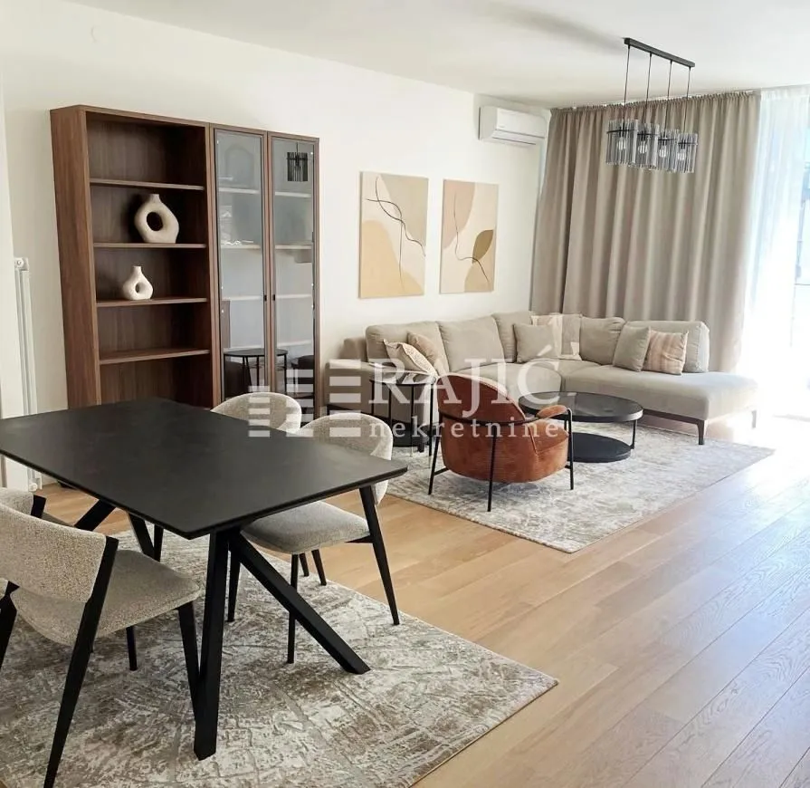 Modern living room with a sofa, dining table, and shelving units.