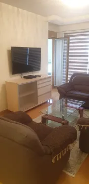 Dnevna soba sa garniturom za sjedjenje i televizorom. - image 4