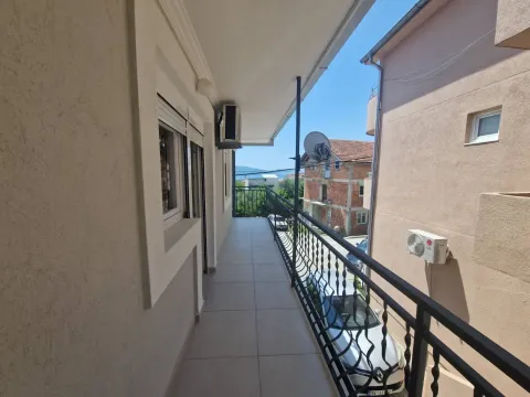 Long tiled balcony with a black railing and a view of surrounding buildings and the street. - image 7