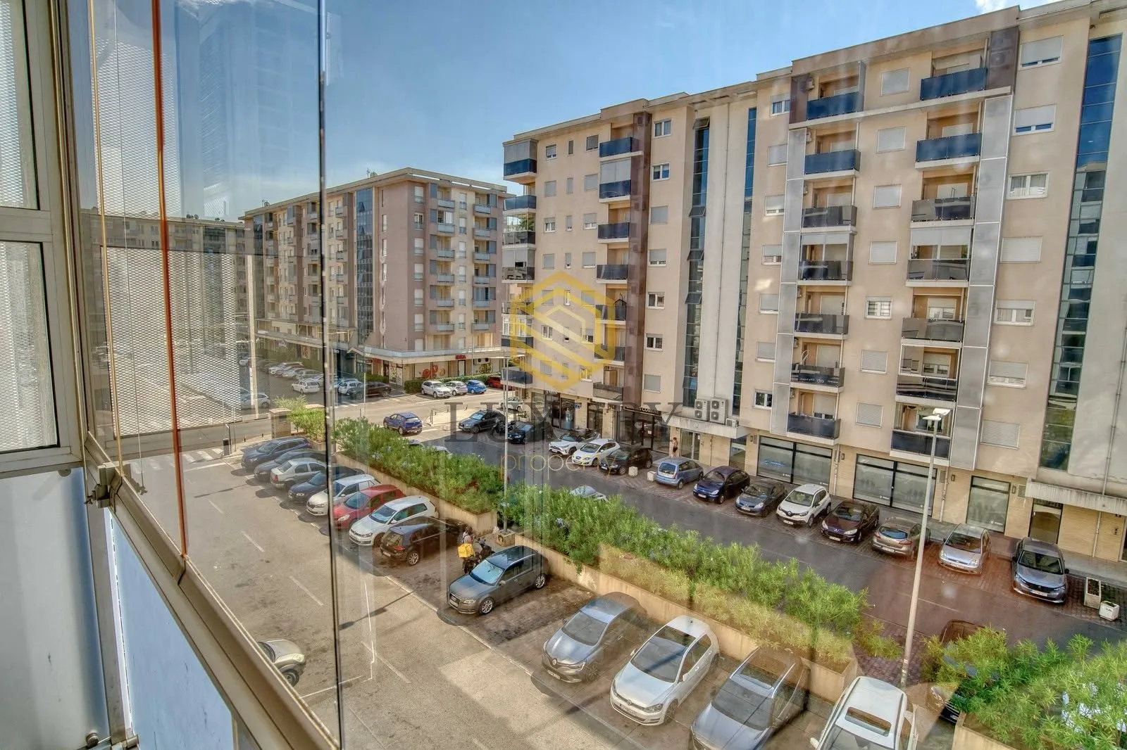 View from the terrace of surrounding residential buildings and parking lot.