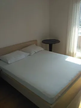Bright bedroom with a double bed and a small table. - image 7