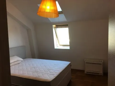 Attic bedroom with a bed and roof windows. - image 6