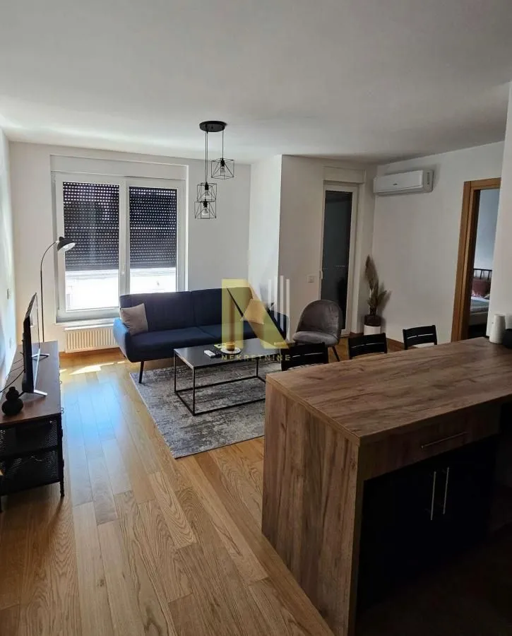 Living room with sofa, coffee table, and kitchen counter in the foreground.