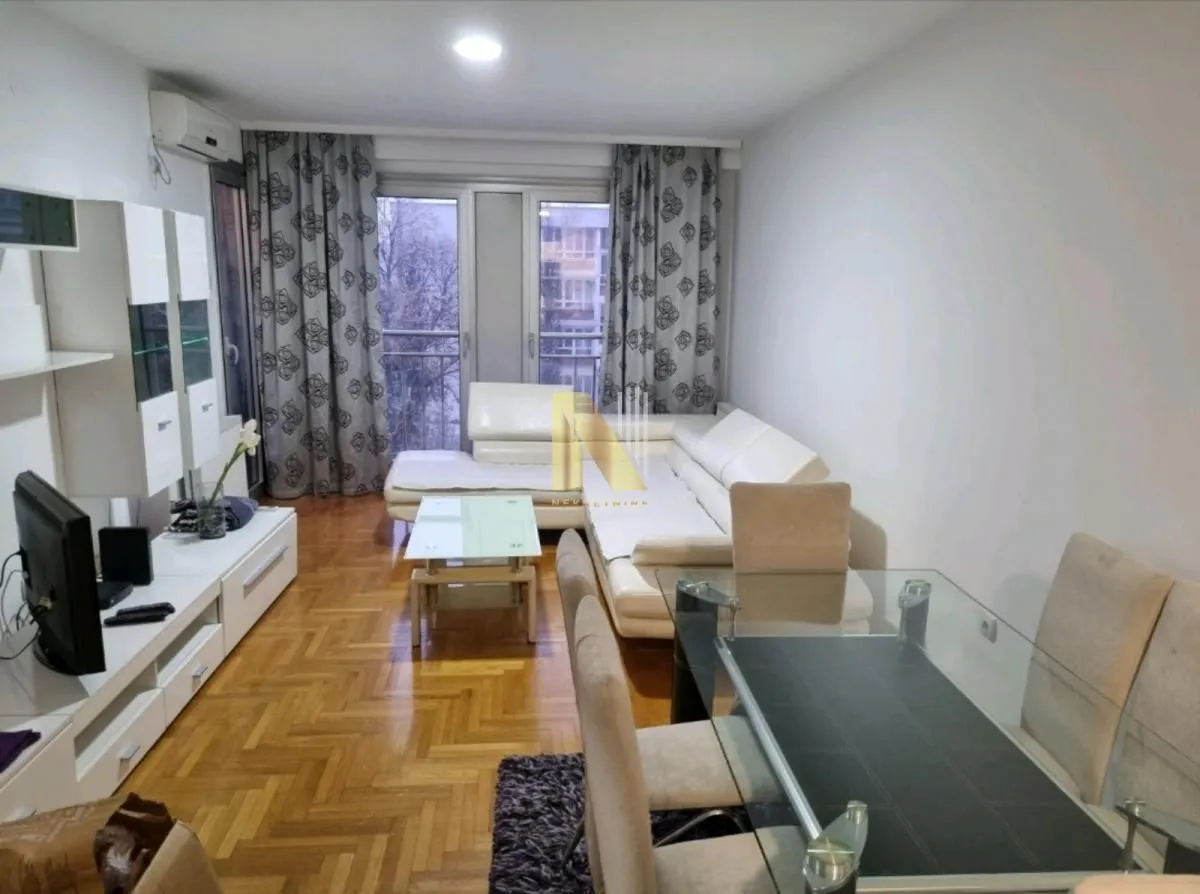 Dnevni boravak sa garniturom, trpezarijskim stolom i izlazom na terasu.