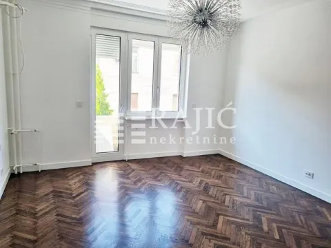Empty room with parquet flooring and a large window. - image 5