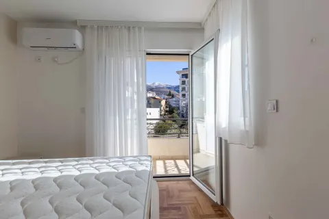 Spavaća soba sa krevetom i izlazom na terasu koja gleda na planine. - image 5