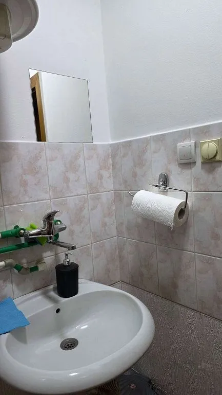 Small bathroom with a sink and tiling.
