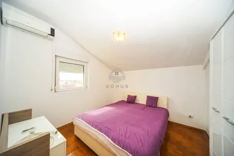 Manja spavaća soba sa bračnim krevetom, bijelim namještajem i krovnim prozorom. - image 4