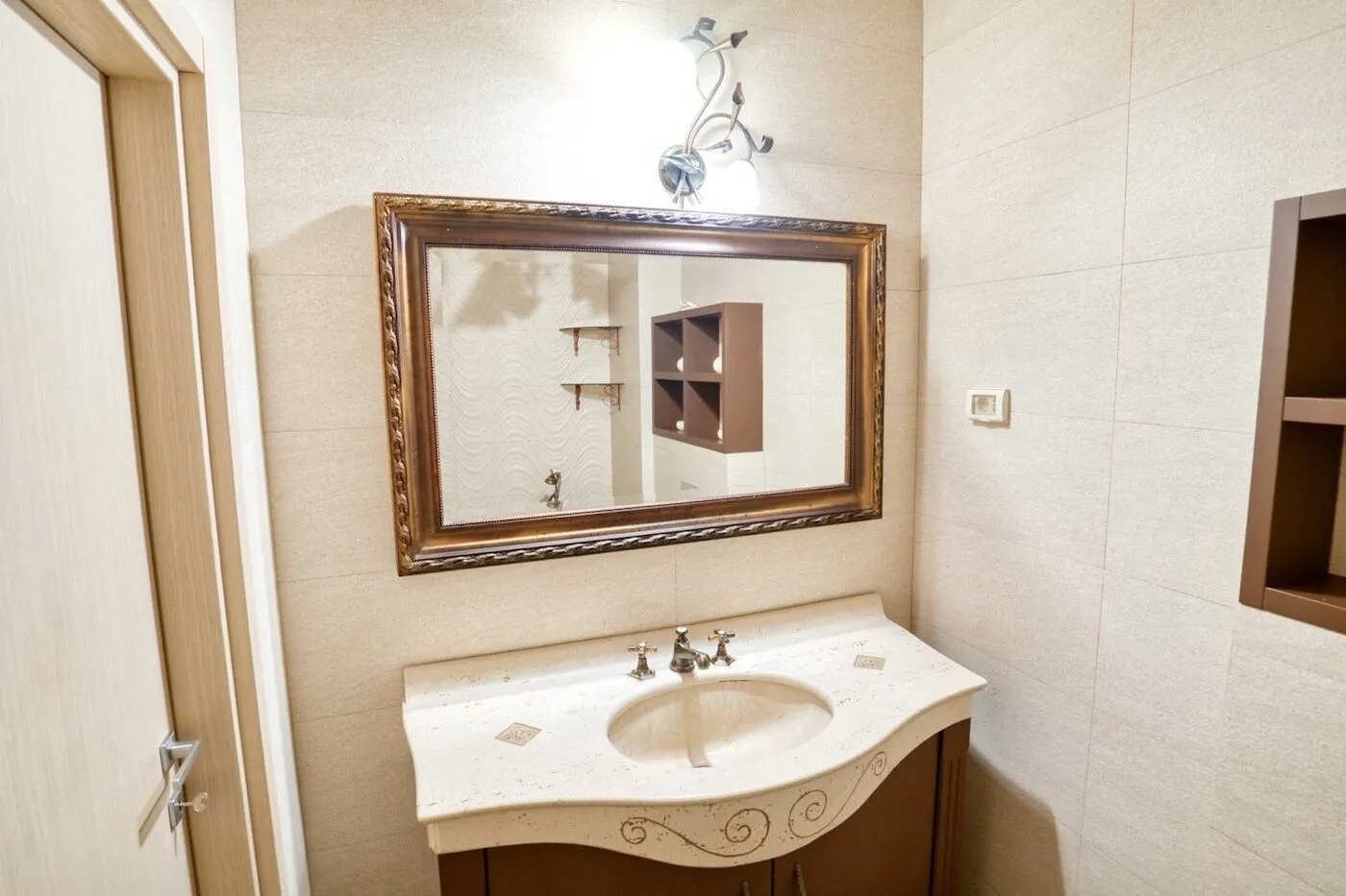 Bathroom with a sink, mirror, and wall tiles.