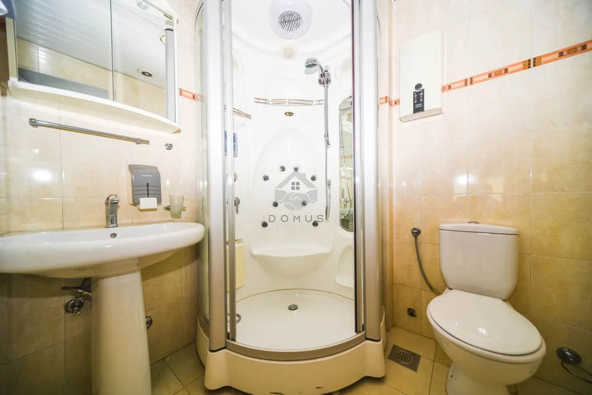 Bathroom equipped with a shower cabin, washbasin, and toilet.