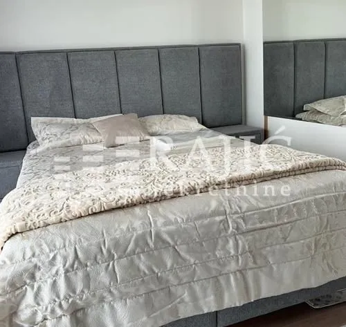 A bedroom with a large double bed and an upholstered headboard.