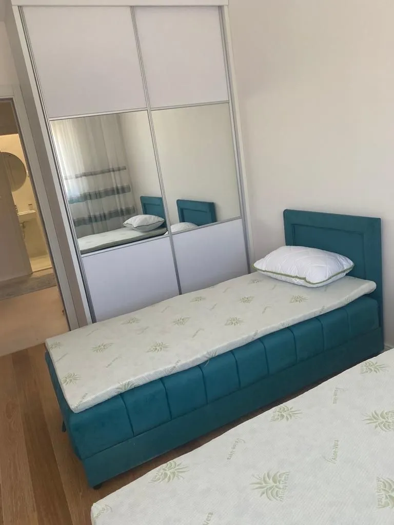 Jednostavna spavaća soba sa krevetima i ugradnim plakarom.