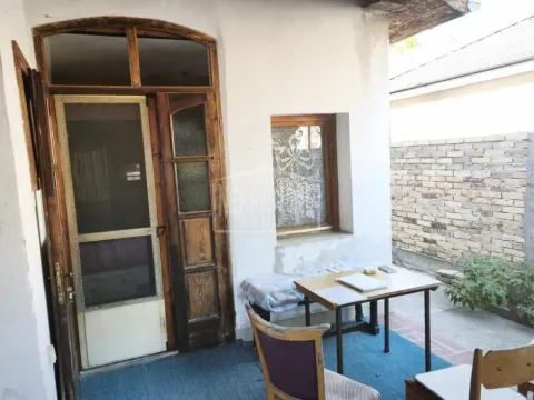 Ulaz u kuću sa drvenim vratima i stolom u dvorištu. - image 4
