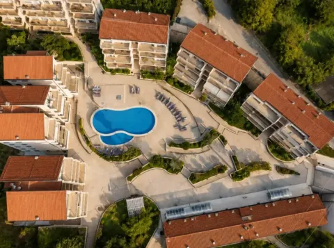 Pogled iz vazduha na stambeni kompleks sa bazenom i uređenim dvorištem. - image 11