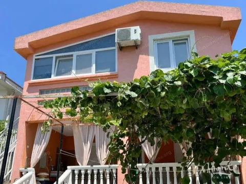 Pogled na spoljašnjost kuće sa natkrivenom terasom i zelenilom. - image 31
