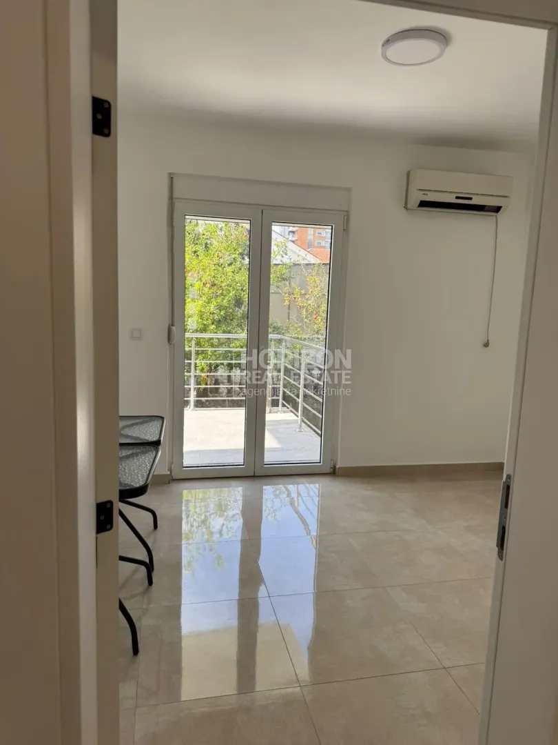 Empty bright room with access to the terrace and an air conditioner.
