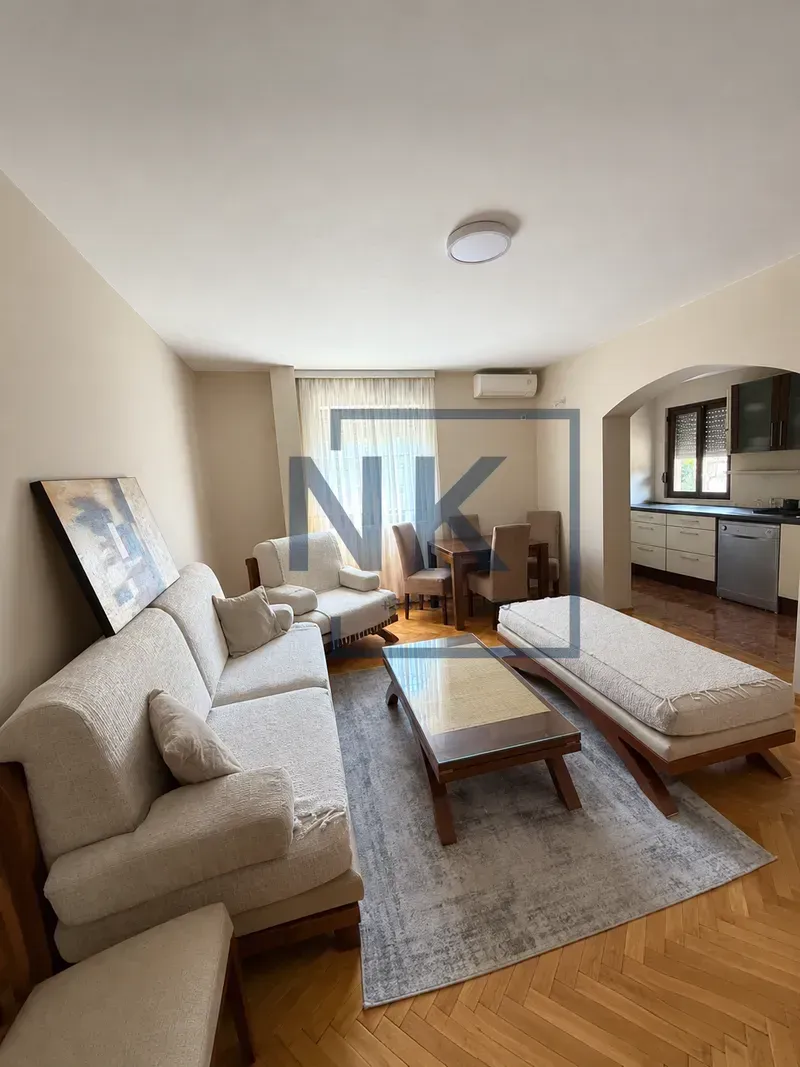 Spacious living room connected to the dining area and kitchen in the background.